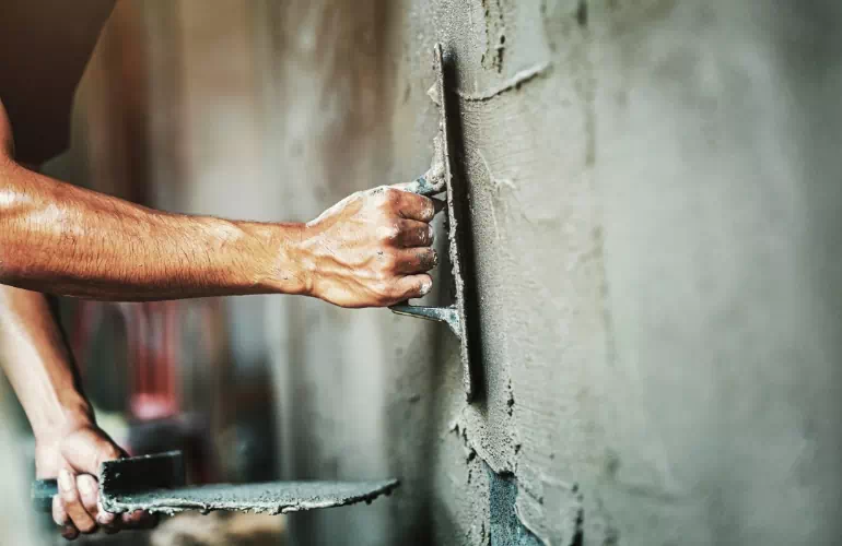 Mężczyzna zacierający betonowe ściany